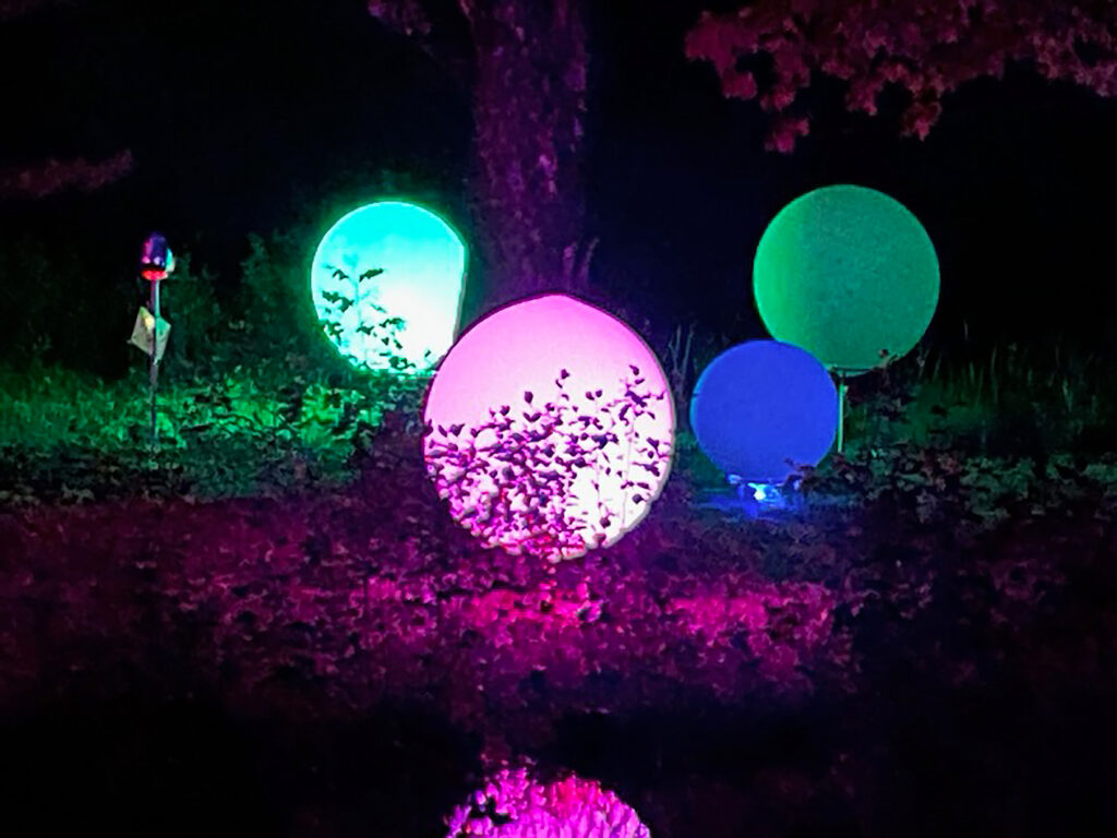 4 glowing orbs reflecting on a body of water.